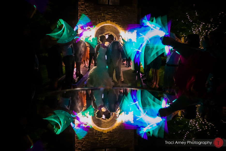 bride and groom exiting wedding with glowsticks and reflected in mirror at vineyard wedding