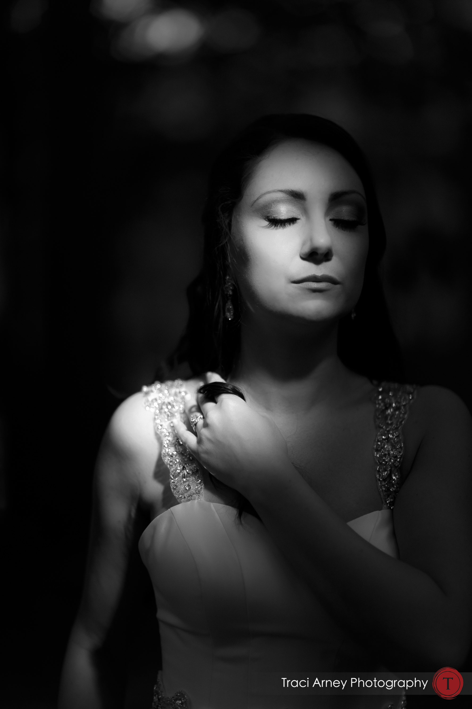 black and white of bride with eyes closed and stream of sunlight on her face