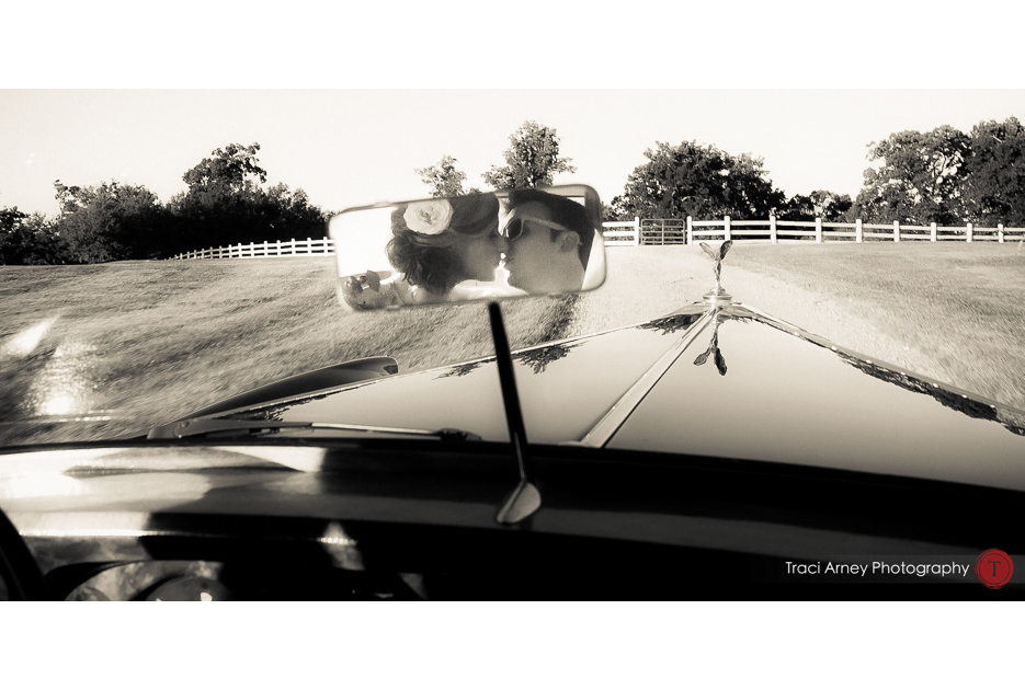 bride and groom seen kissing in rear view mirror of their rolls royce get away car at an outdoor wedding at Adaumont Farms at Trinity, NC